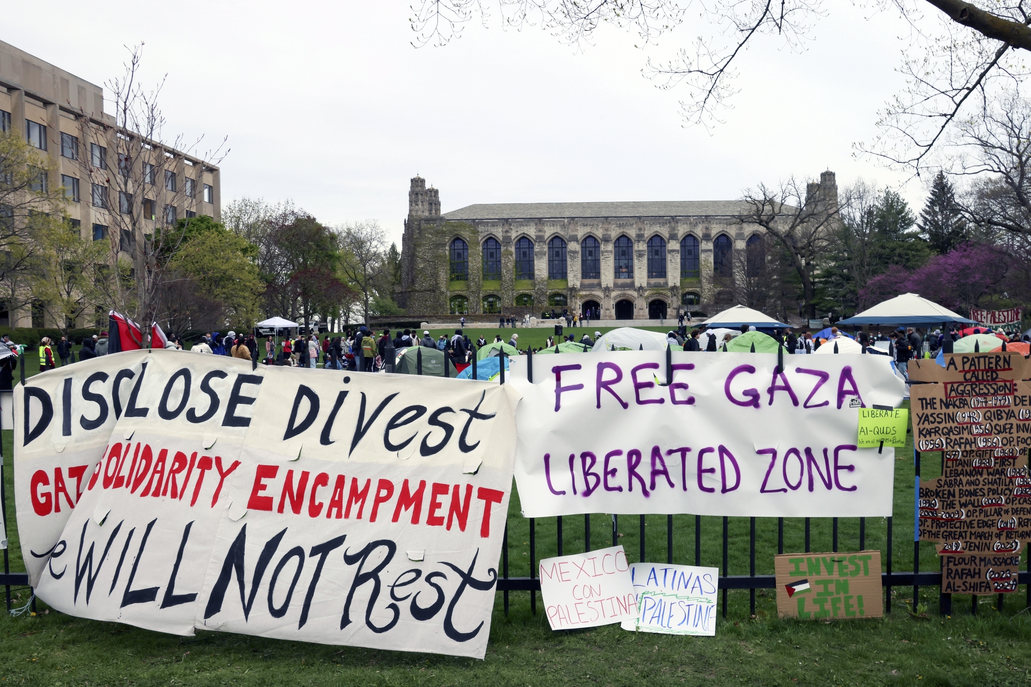 Signs are displayed outside a tent encampment at Northwestern University on April 26, 2024, in Evanston, Ill.
